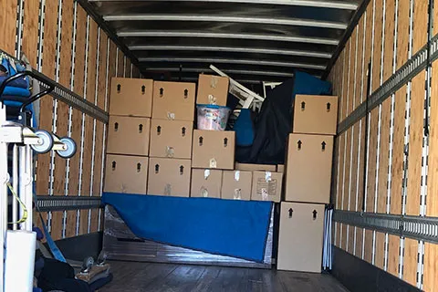 Moving truck loaded with packed boxes and wrapped furniture